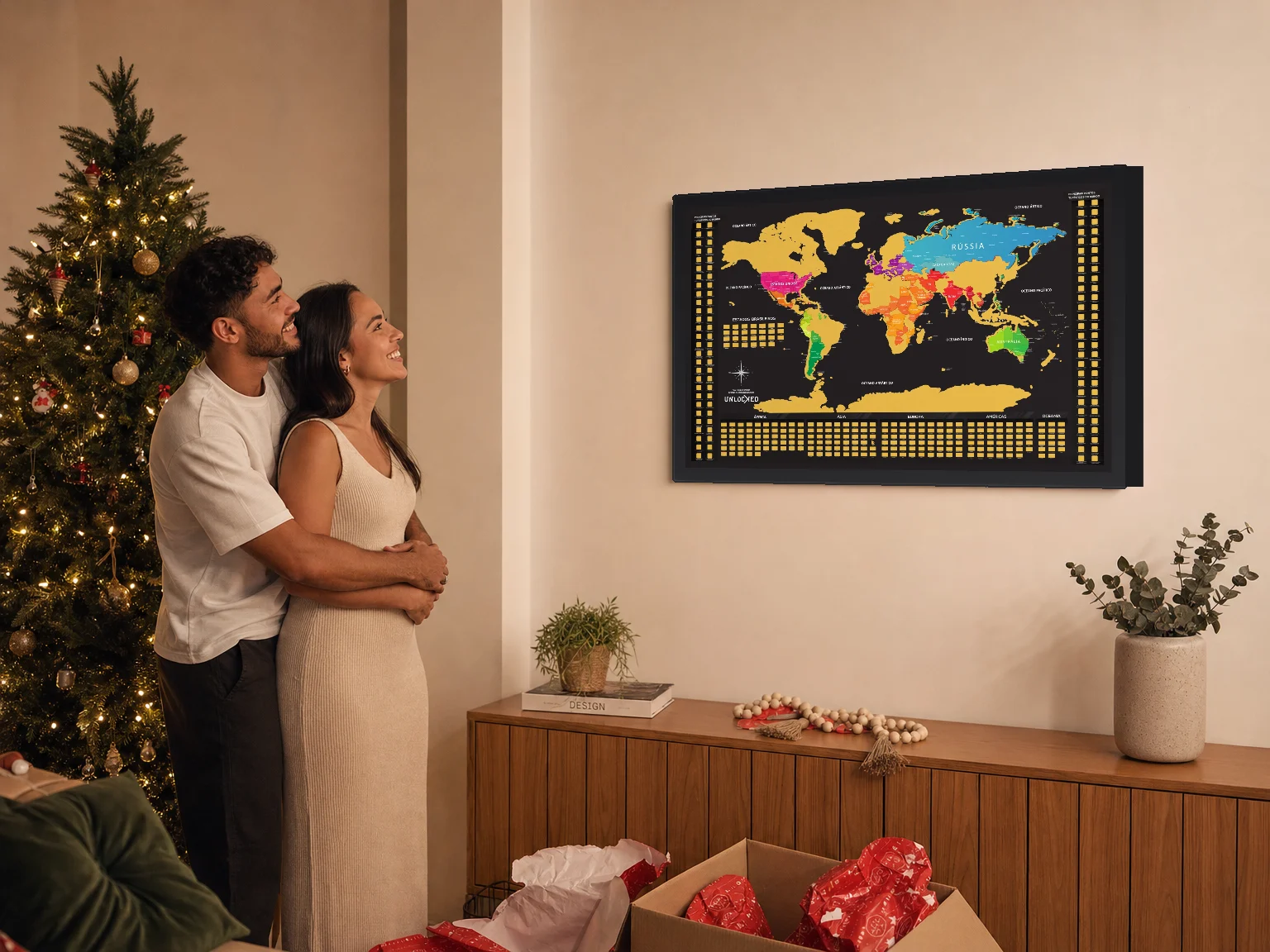 Casal abraçado diante do Mapa Mundi que acabou de ganhar de Natal